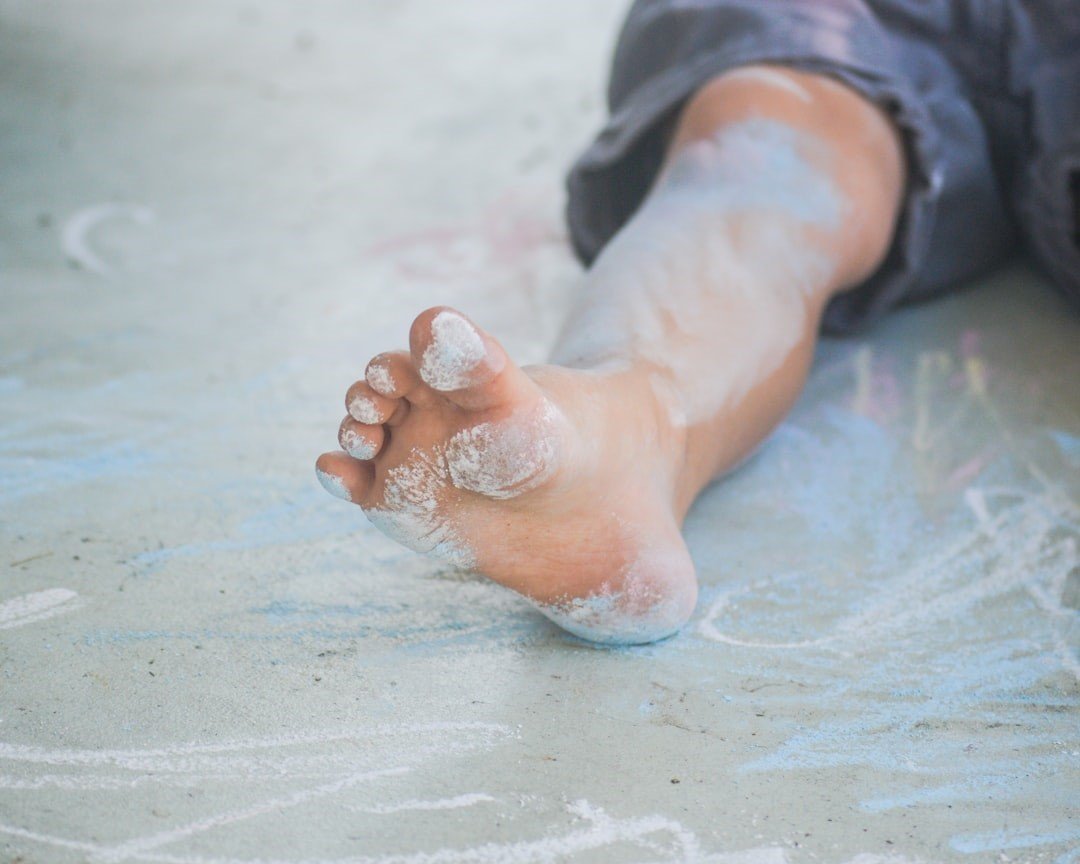 Close up photo of child's foot on sand