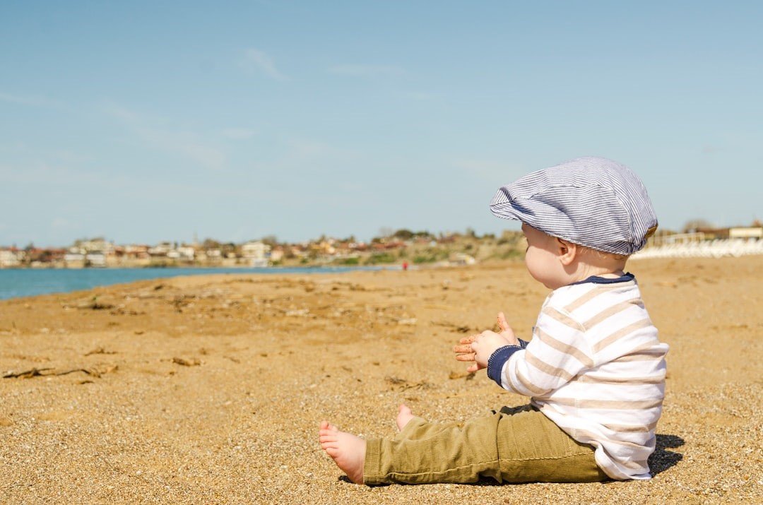 A baby sitting on a beach