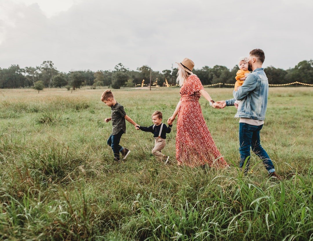 A family is walking on grass field