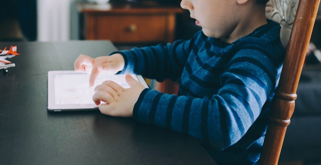 A Boy is playing with tablet on desk