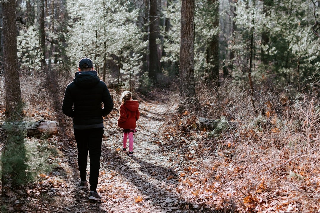 A father and little girl walking together inside bush