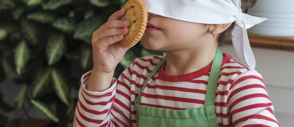 A boy is blindfolded and smell various items