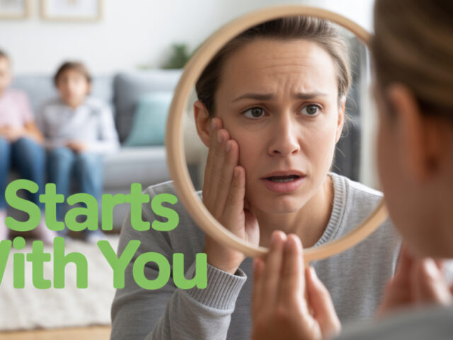 A mom looking at a mirror and two children sitting on couch at the background